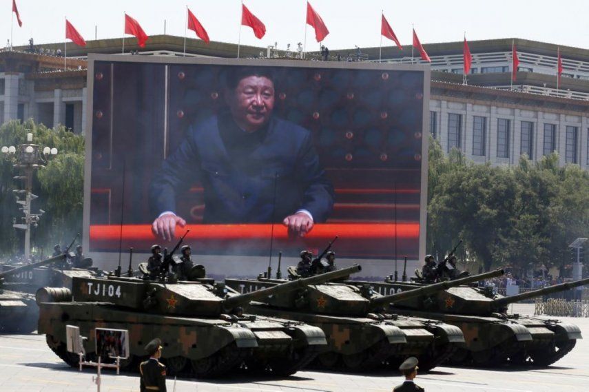 El presidente de China, Xi Jinping, aparece en una pantalla mientras varios tanques de Tipo 99A2 participan en un desfile en Pekín.