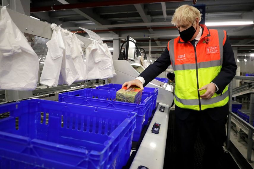 El primer ministro británico Boris Johnson coloca alimentos en canastas de plástico el miércoles 11 de noviembre de 2020 durante una visita a un centro de distribución en línea de los supermercados Tesco, en Londres.&nbsp;