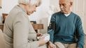 Una mujer chequea la presión arterial a una persona de la tercera edad.