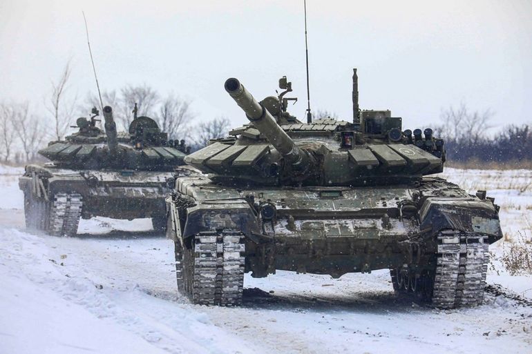 En esta imagen proporcionada por el Servicio de Prensa del Ministerio ruso de Defensa el lunes 14 de febrero de 2022, tanques rusos pasan por un campo durante maniobras militares en la región de Leningrado, Rusia.