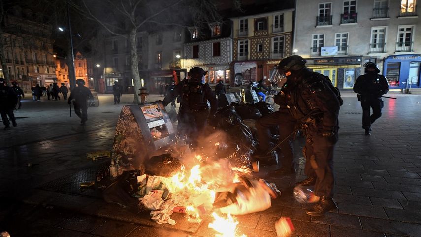 La policía francesa CRS (Compagnie Republicaine de Securite o Cuerpo de Seguridad Republicano) extingue la basura incendiada durante las protestas en Rennes, oeste de Francia, el 18 de marzo de 2023, dos días después de que el gobierno francés impusiera una reforma de pensiones utilizando el artículo 49,3 de la constitución.