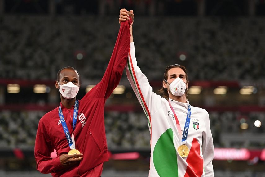 Los medallistas de oro conjuntos Mutaz Essa Barshim (R) de Qatar y Gianmarco Tamberi de Italia posan en el podio de la final masculina de salto de altura durante los Juegos Olímpicos de Tokio 2020