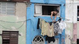 Una mujer pone su ropa a secar en un edificio en Cuba.&nbsp;