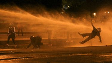 Un manifestante cae al ser alcanzado por un cañón de agua durante los enfrentamientos con la policía antidisturbios en medio de las continuas protestas contra el gobierno del presidente colombiano Iván Duque en Bogotá el 12 de junio de 2021.&nbsp;