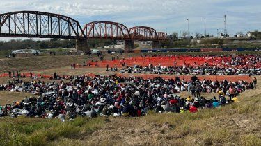 Centenares de migrantes en espera de ser atendidos por agentes de la Oficina de Aduana y Protección Fronteriza (CBP, por sus siglas en inglés), en el puesto fronterizo Eagle Pass, en Texas.