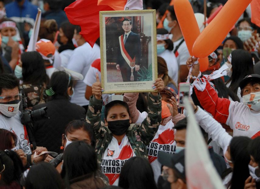 Una partidaria de la candidata presidencial de derecha Keiko Fujimori sostiene un retrato de su padre, el expresidente peruano Alberto Fujimori durante el mitin de clausura de su campaña en Lima, el 3 de junio de 2021.