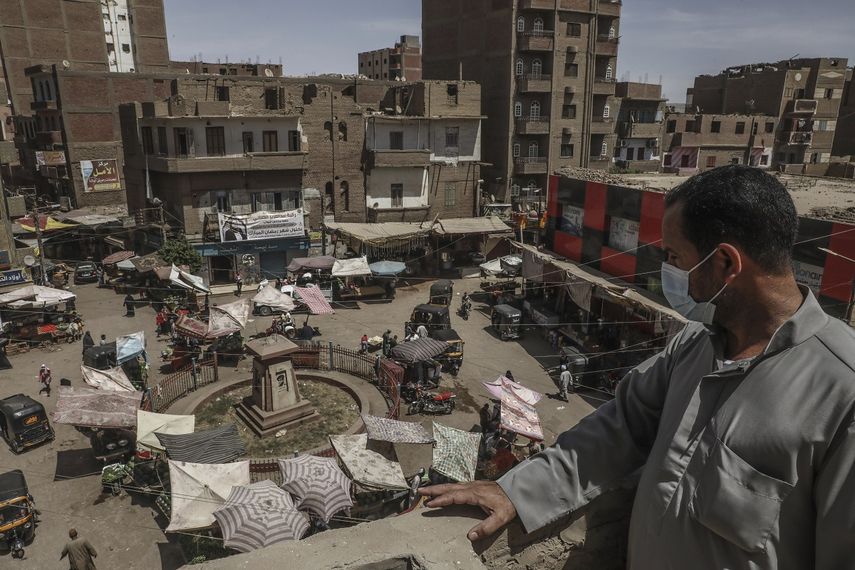 Ashraf Sayed, residente de la población de Monshah, donde hay un auge del coronavirus, contempla un mercado desde lo alto de un edificio en Sohag, Egipto, 2 de mayo de 2021.&nbsp;