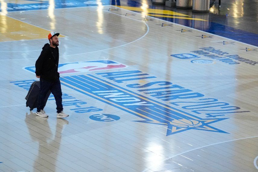 Los viajeros que utilizan el Aeropuerto Internacional de Indianápolis cruzan una réplica de la cancha que se usará para el Juego de Estrellas de la NBA el jueves 18 de enero de 2024. Las autoridades han creado una réplica de la cancha de baloncesto de tamaño real con dos canastas, una equipada con un reloj corto, para promover el primer Juego de Estrellas de Indy desde 1984.&nbsp;