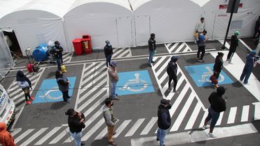 Personas mantienen sana distancia mientras esperan noticias de sus familiares, hospitalizados por COVID-19 a las afueras del Instituto de Seguridad Social hospital en Quito, Ecuador, el lunes 27 de julio de 2020