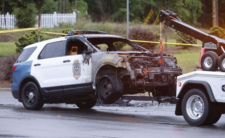 Un vehículo policial quemado siendo remolcado fuera de una estación de policía en el sureste de Raleigh, Carolina del Norte, el sábado 7 de mayo de 2022.&nbsp;