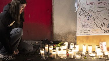 Una fan junto a un altar improvisado para el fallecido cantante Liam Payne en el Foro de Copenhague.