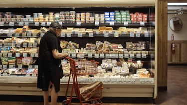 Una persona de edad avanzada compra en un supermercado en Nueva York.
