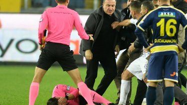 En esta imagen de archivo, el árbitro Halil Umut Meler se sujeta el rostro mientras está tirado sobre el piso luego de recibir un golpe del presidente del MKE Ankaragucu, Faruk Koca (centro), al final de un partido de la Superliga turca frente al Caykur Rizespor, en Ankara, el 11 de diciembre de 2023.&nbsp;