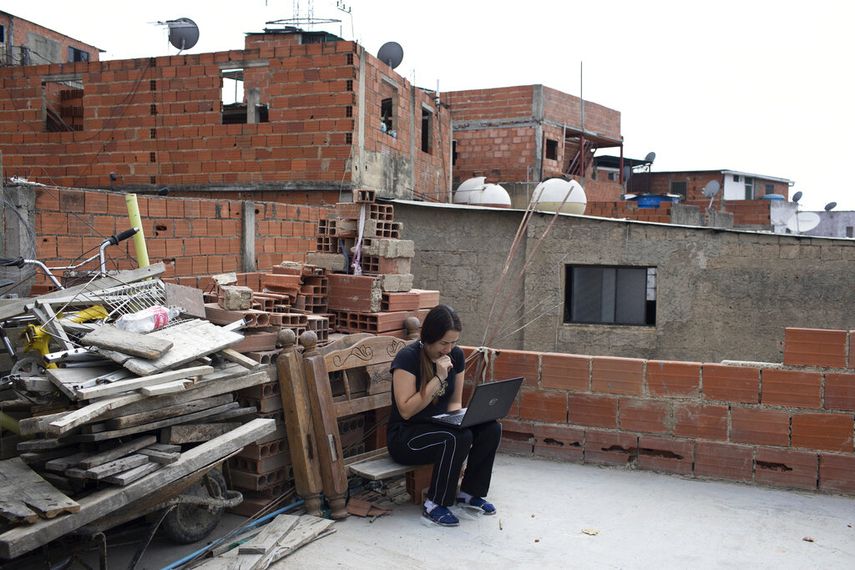 Maria Figueroa se conecta a la internet en el techo de su casa para enviar a la escuela las tareas de su hijo el 6 de mayo del 2020 en el barrio Catia de Caracas. La vivienda llevaba dos semanas sin agua corriente.