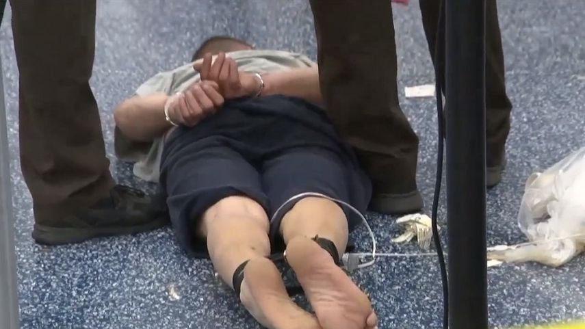 Emilio Nivaldo López (en el suelo) fue atado de pies y manos tras protagonizar una agresión a un agente federal en el Aeropuerto Internacional de Miami.