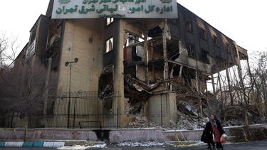 Residentes pasan junto al edificio de la oficina de impuestos, que se incendió durante las recientes protestas antigubernamentales en Teherán, Irán, el 21 de enero de 2026. Irán sufre un apagón nacional de internet que comenzó el 8 de enero de 2026, en medio de una creciente ola de protestas antigubernamentales.&nbsp;