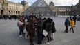 Turistas esperan y empleados en huelga se manifiestan en la entrada al Museo del Louvre, Par&iacute;s, viernes 17 de enero de 2020. El museo estaba cerrado en medio de huelgas contra el plan del gobierno de reformar el sistema jubilatorio.&nbsp;