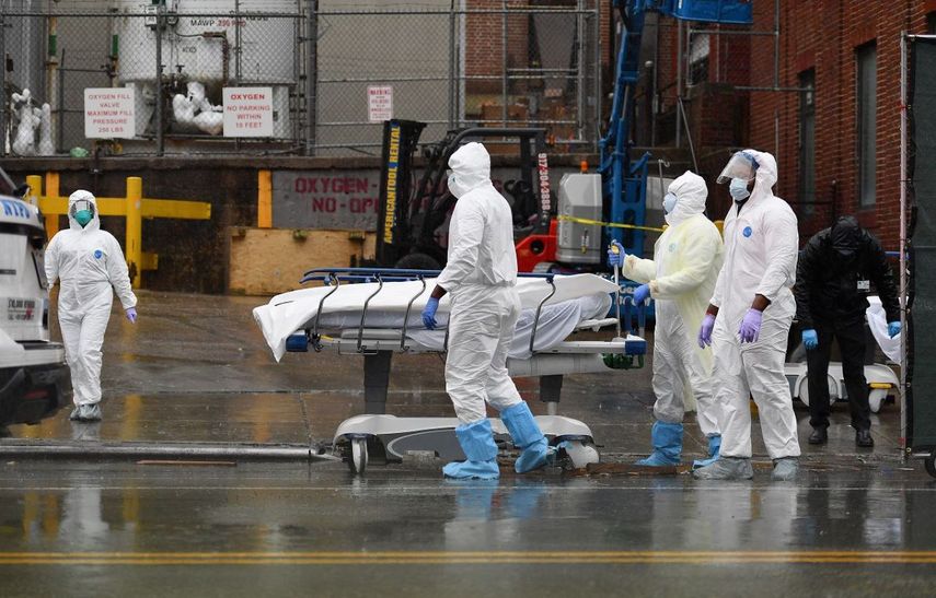 Paramédicos trasladan a uno de los fallecidos por COVID-19 a la morgue.