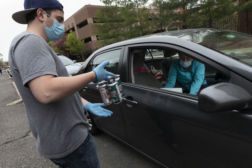 En esta foto del 8 de mayo del 2020, el empleado de la microcervecer&iacute;a Jacks Abby Casey Mott le lleva un pedido a un cliente en una fila de autos a la espera en Framingham, Massachusetts.&nbsp;