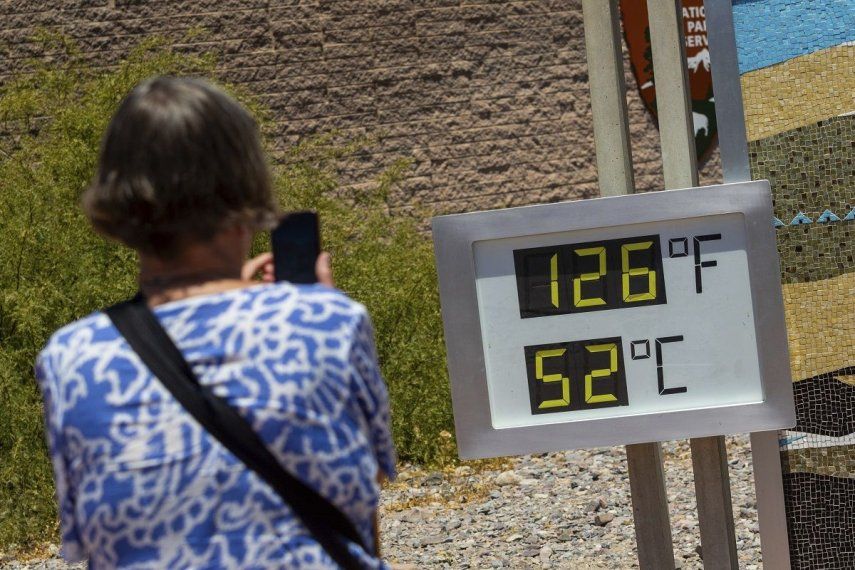 Una mujer toma una fotografía de un termostato que marca 52 grados Celsius y 126 grados Fahrenheit el domingo 7 de julio de 2024, en el Centro de Visitantes de Furnace Creek, en el Parque Nacional del Valle de la Muerte, California.&nbsp;