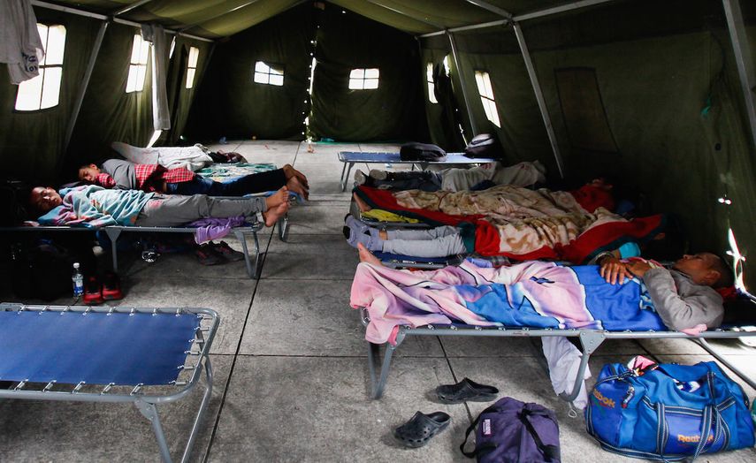 Un grupo de hombres duerme en un cuartel militar en Ecuador habilitado para ofrecer apoyo a los venezolanos que huyen de la crisis de su país. 