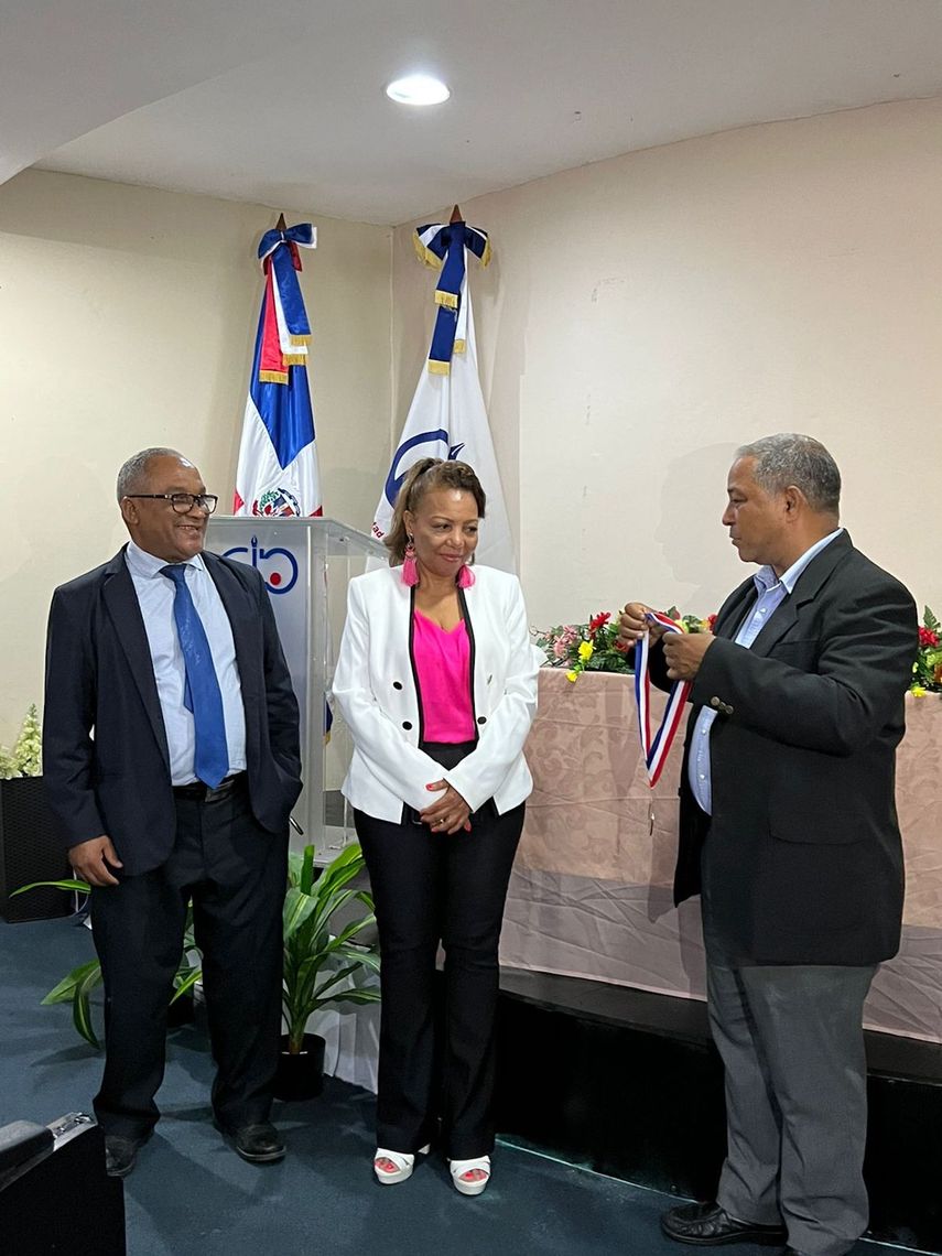 En la gráfica, en nombre del Comité Ejecutivo del gremio, su presidente Aurelio Henríquez adjunto a Olivo de León, presidente del IPPP, mientras hacen entrega de la honrosa medalla a la periodista Rose Mary Santana.&nbsp;