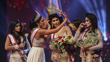En esta foto de archivo tomada el 4 de abril de 2021, la ganadora de Mrs. Sri Lanka 2020, Caroline Jurie, quita la corona de la ganadora de 2021, Pushpika de Silva, tras ser descalificada por la acusación de estar divorciada en un salón de belleza.