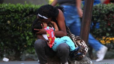 Una mujer venezolana abraza a su hijo en una acera de Colombia mientras espera para seguir su camino hacia Perú.&nbsp;