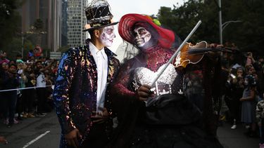 Una pareja vestida de “Catrinas” desfila por la emblemática avenida Reforma en la Ciudad de México en un prólogo del Día de Muertos, el sábado 26 de octubre de 2019. 
