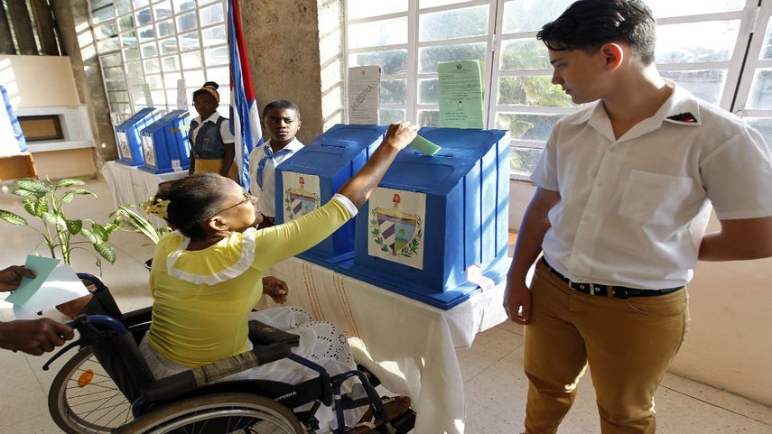 Una mujer deposita su voto en la urna durante las elecciones de la Asamblea Nacional en Cuba