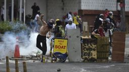 Un manifestante lanza una piedra a los agentes de la policía antidisturbios durante una protesta contra el gobierno en Cali, Colombia.