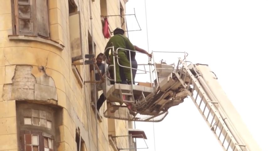 Personal especializado de los bomberos ayudan a los residentes que permanecen en el edificio a entrar y salir de sus viviendas.