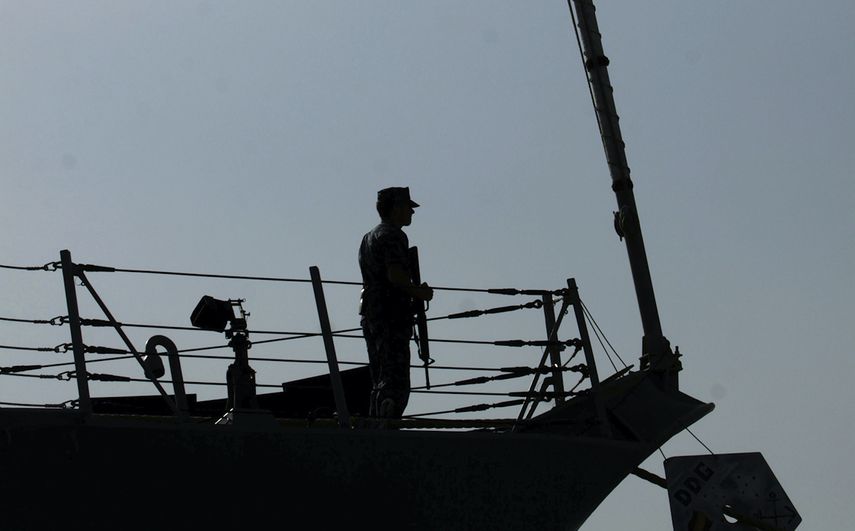 En esta foto del 12 de enero del 2012, un marinero estadounidense es visto junto a la bandera de Estados Unidos durante una ceremonia de cambio de comando a bordo del destructor USS Kidd, atracado en Muharraq, Bahr&eacute;in.&nbsp;