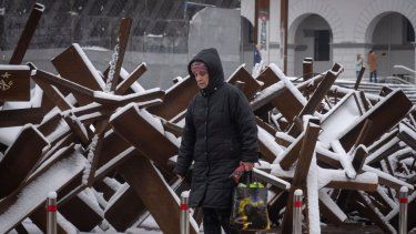 Una mujer camina frente a una barricada antitanques, el lunes 12 de diciembre de 2022, en Kiev, Ucrania.&nbsp;