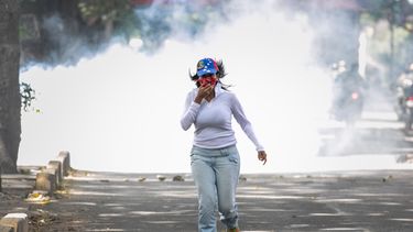Mujer huye de los gases lacrimógenos lanzado contra manifestantes pacíficos en Montalbán.&nbsp;