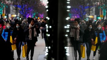 Compradores se reflejan en una ventana mientras caminan por Oxford Street, la calle para compras más ajetreada de Europa, en Londres, el jueves 23 de diciembre de 2021.