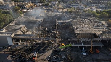 Bomberos del Servicio Ucraniano de Emergencias trabajan para retirar los escombros de un centro comercial calcinado tras el impacto de un cohete de en Kremenchuk, Ucrania, el martes 28 de junio de 2022.&nbsp;
