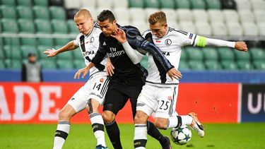 Cristiano Ronaldo (centro) del Real Madrid disputa el balón con Jakub Rzezniczak (derecha) y Adam Hlousek (izquierda) del Legia de Varsovia