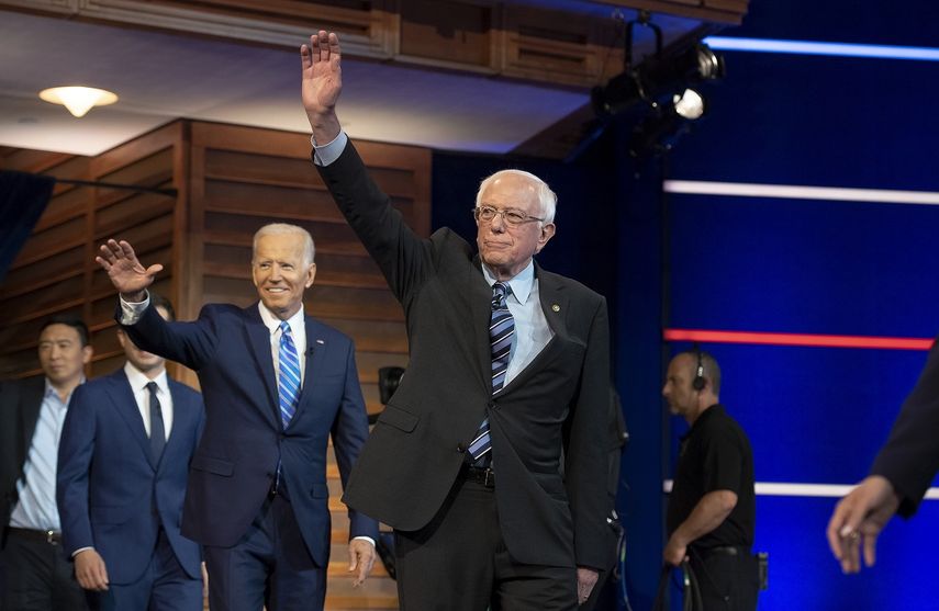 Los candidatos Bernie Sanders (der.) y Joe Biden saludan a su llegada al Adrienne Arsht Center, en Miami, el 27 de junio de 2019, para participar en el debate demócrata.