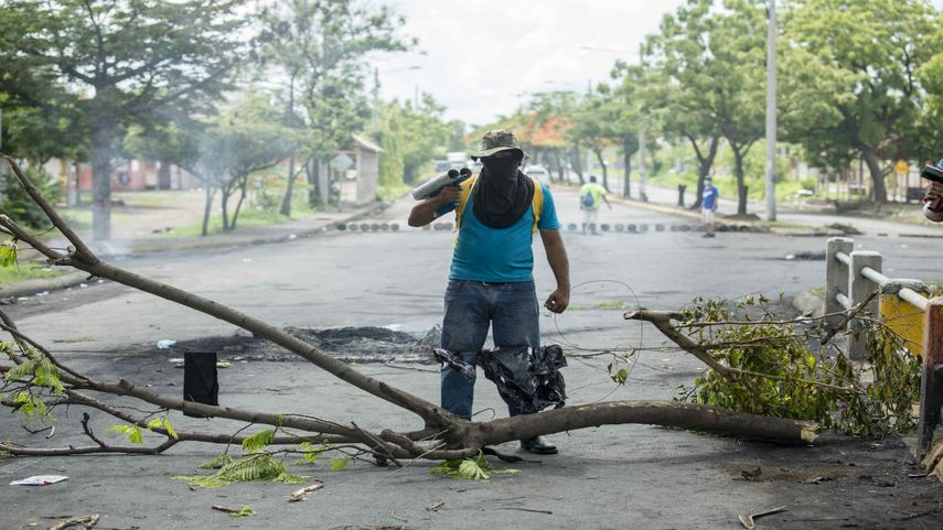 Un joven con un mortero en sus hombros cuida una barricada en Managua