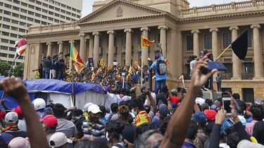 Manifestantes, muchos con banderas de Sri Lanka, se reúnen en torno a la oficina del presidente en Colombo, Sri Lanka, el sábado 9 de julio de 2022.