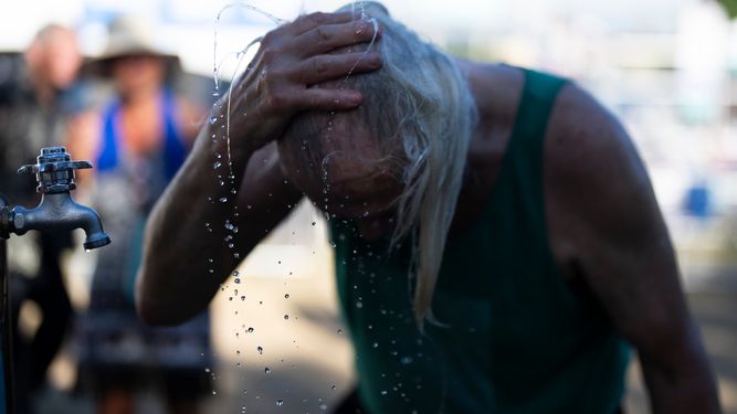 Una persona se refresca del calor imperante.&nbsp;