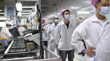 Empleados se forman para someterse a una prueba de coronavirus en una fábrica de Wuhan, China, el 5 de agosto de 2021.&nbsp;