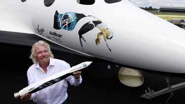 En esta foto de archivo del 11 de julio de 2012, el multimillonario británico Richard Branson sostiene un modelo de LauncherOne, un cohete que se usará para lanzar pequeños satélites al espacio, en el Salón Aeronáutico Internacional de Farnborough en Farnborough, Inglaterra.&nbsp;