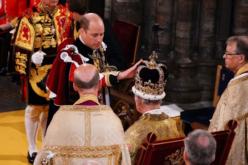 El Príncipe William, Príncipe de Gales de Gran Bretaña, toca la corona de San Eduardo en la cabeza de su padre, el Rey Carlos III de Gran Bretaña, durante la Ceremonia de Coronación del Rey dentro de la Abadía de Westminster en el centro de Londres el 6 de mayo de 2023.  
