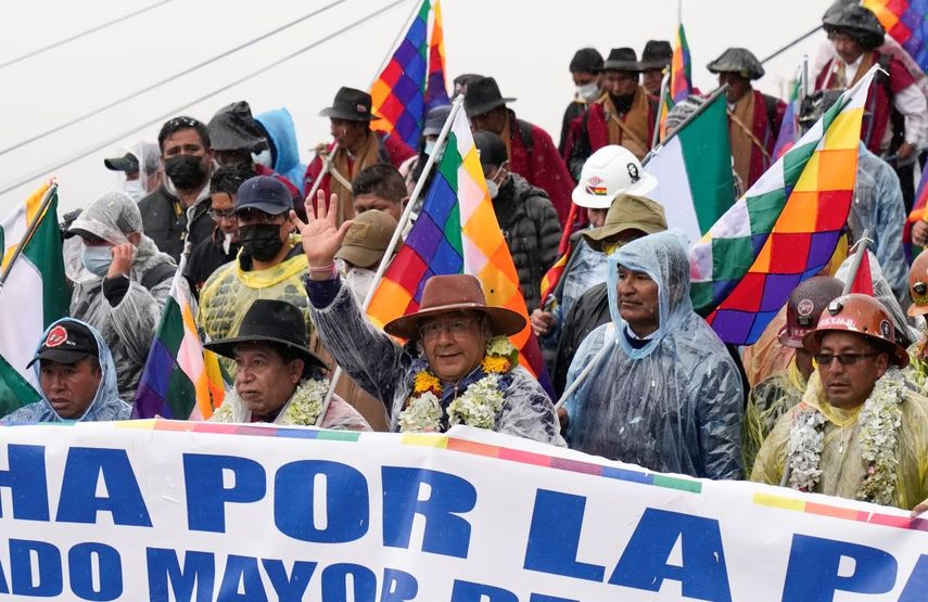 El presidente de Bolivia, Luis Arce, en el centro, saluda mientras camina con su vicepresidente David Choquehuanca, segundo a la izquierda, y con el expresidente Evo Morales, segundo a la derecha, durante una marcha en La Paz, Bolivia, el lunes 29 de noviembre de 2021.
