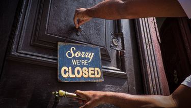 Una persona coloca el cartel de cerrado a las puertas de un caf&eacute;, en La Habana, Cuba.&nbsp;
