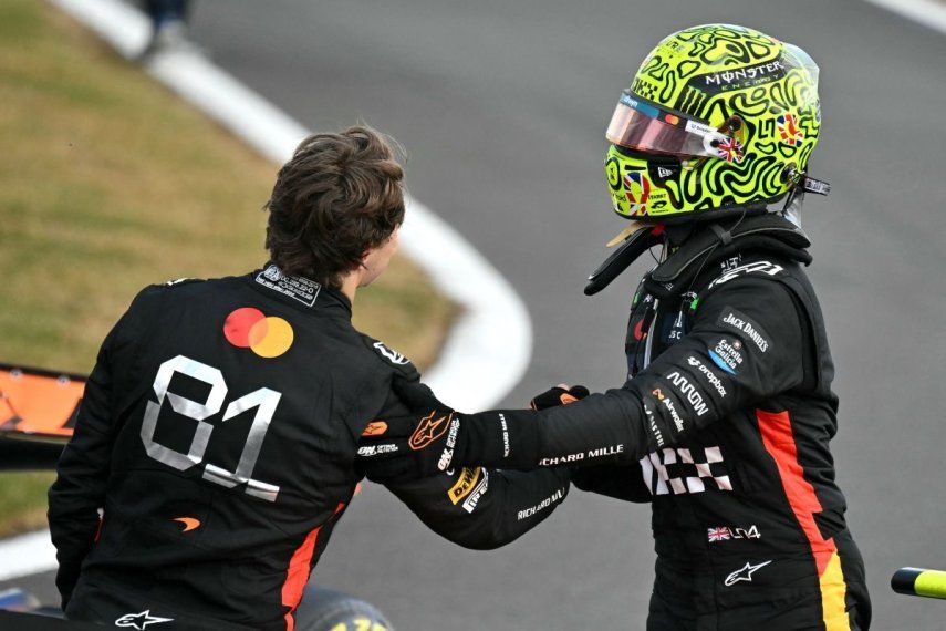 El piloto británico de McLaren, Lando Norris, estrecha la mano del piloto australiano de McLaren, Oscar Piastri (L), después de ganar el Gran Premio de Gran Bretaña de Fórmula 1 en el circuito de automovilismo de Silverstone en Silverstone, en el centro de Inglaterra, el 6 de julio de 2025.