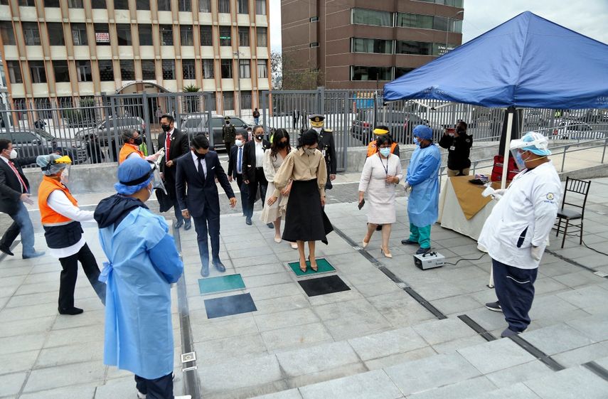Folleto publicado por la Asamblea Nacional de Ecuador que muestra a la nueva Vicepresidenta de Ecuador, Mar&iacute;a Alejandra Mu&ntilde;oz (C) desinfectando sus zapatos contra la propagaci&oacute;n del nuevo coronavirus COVID-19 al llegar a su inauguraci&oacute;n en la Asamblea Nacional en Quito el 22 de julio, 2020.