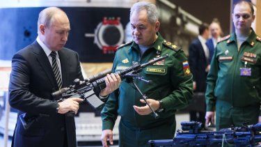 El presidente ruso Vladimir Putin y el ministro de Defensa Sergei Shoigu recorren una exhibición de equipos militares antes de la reunión anual de la junta del Ministerio de Defensa en Moscú.